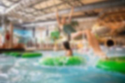 Far og børn går balancegang på åkanderne i aktivitetsbassinet Lalandia i Billund