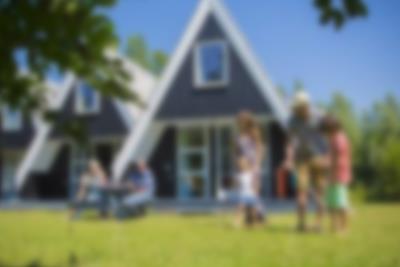 Familien spiller krokket foran feriehuset i Lalandia mens besteforeldrene ser på