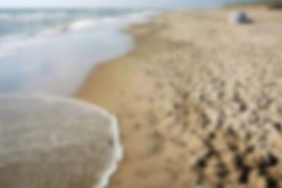 La føttene synke ned i den fine sanden som dekker stranden