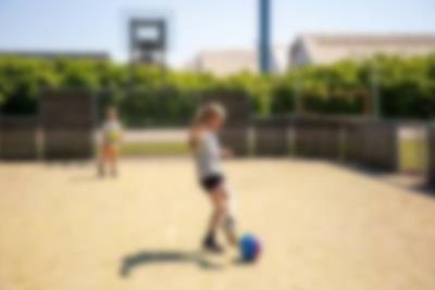 A father plays ball with his children on a multipurpose pitch at Lalandia